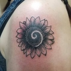 a sunflower tattoo on the back of a woman's shoulder