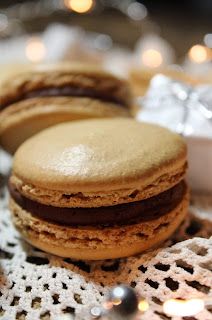 some cookies are sitting on a doily with lights in the backgroung