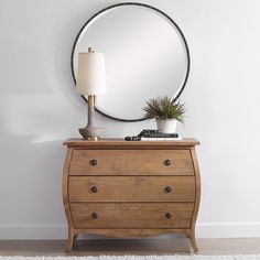 a dresser with a mirror on top and a plant in the middle next to it