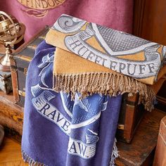 a blue and yellow blanket sitting on top of a wooden table next to an old trunk