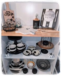 the shelves are filled with black and white plates, bowls, and other decorative items