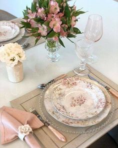 a table set with pink and white flowers