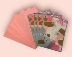 five cards with different designs on them, one is pink and the other is blue