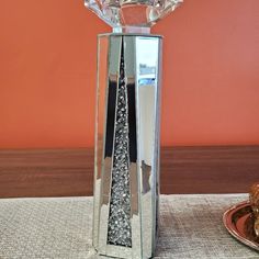 a crystal vase sitting on top of a table next to a plate filled with food