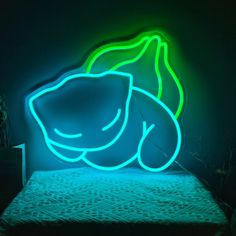 a lit up bed in a dark room with green and blue lights on the wall