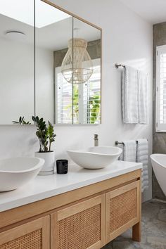 a bathroom with two sinks and a large mirror on the wall next to each other