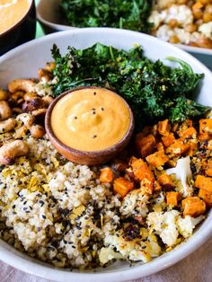 a white bowl filled with rice and vegetables next to other bowls full of different types of food