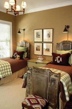 two twin beds in a bedroom with brown and green bedding, framed pictures on the wall