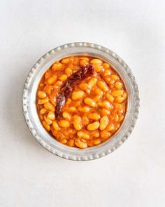 a bowl filled with beans on top of a white table