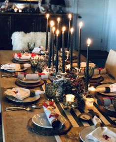 a dining room table is set with candles and place settings for the holiday dinner party