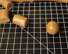 a group of wooden objects sitting on top of a black table next to a ruler