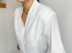 Large, Embroidered Blouse. Beautifully detailed, this cream ladies blouse dates from the early 2000s and looks fabulous teamed with jeans or a skirt. Buttoned down the front, the embroidered detailing is especially lovely. Polyester, x2 spare buttons still attached. Light and easy to wear. Condition: Excellent vintage condition Measurements: Contrary to the UK20 label - and depending upon your preferred fit, the measurements tally with: UK 16-18 EU 44-46 US 14-16 Bust: 44 inches / 111 cm Length: 24 inches / 61 cm Ready to wear. Evening Blouses, The Early 2000s, Ladies Blouse, Beautiful Blouses, Embroidered Blouse, Early 2000s, Womens Clothing Tops, Favorite Outfit, Blouses For Women