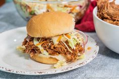 a pulled pork sandwich with cole slaw on the side