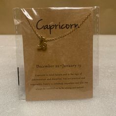 a card with a gold necklace on it that reads capricorn december 24 - january 19