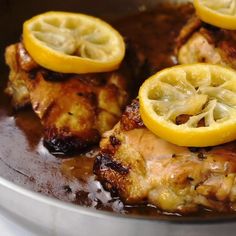 chicken with lemon slices and sauce in a pan