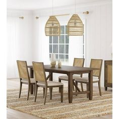 a dining room table and chairs with an area rug in front of the window that is open