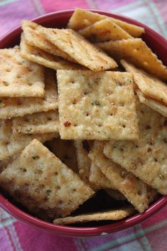 a red bowl filled with crackers on top of a table