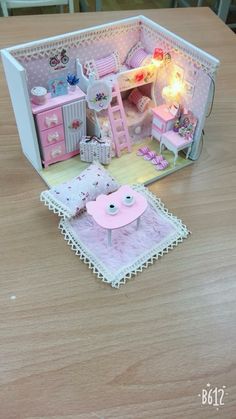 a doll house with furniture and accessories on a table in front of a chair that is lit up