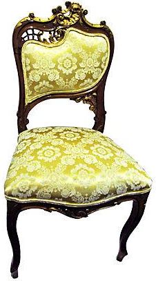 an old fashioned chair with yellow fabric on it's back and seat, against a white background