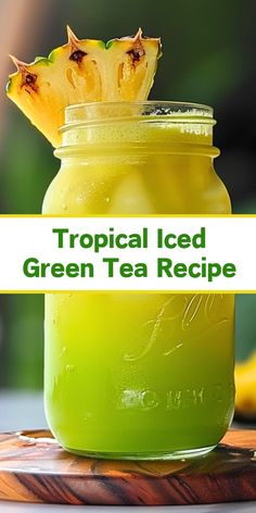 tropical iced green tea recipe in a mason jar with pineapple on top and text overlay that reads, tropical iced green tea recipe