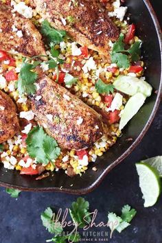 a skillet filled with chicken, corn and cilantros on top of a table