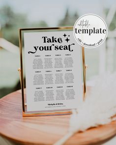 a table with a sign that says take your seat on it and a white feather