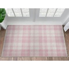 a pink and white plaid rug on the floor