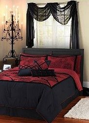 a bed with red and black comforters in a bedroom next to a chandelier