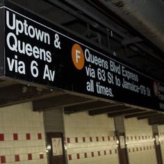 a sign for the queen and f via 6 av in an underground subway station with red and white striped walls