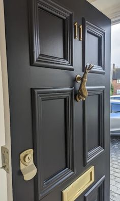 a black door with brass handles and knobs on the front entrance to a house