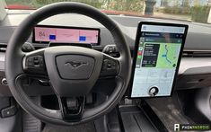 the interior of a car with an electronic device in front of it and a tablet on the dashboard