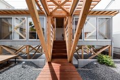 a wooden walkway leading up to a building with windows and wood slats on the sides