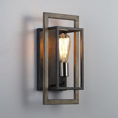 a light that is on the side of a wall next to a gray wall with a lamp in it