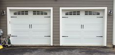 three white garage doors in front of a house