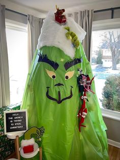 a large green costume is on display in front of a window