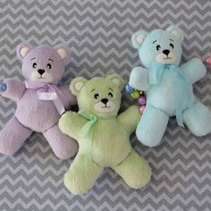 three stuffed teddy bears sitting next to each other on a gray and white chevron background