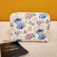 Experience A Touch Of The Tropics With This Lilo & Stitch Wallet! This Accessory Features An Allover Print Of Stitch, Ducklings, And Flowers On Cream-Colored Fabric. With Four Card Slots And A Clear Id Sleeve, It's Perfect For Storing Your Valuables! * * * * Features * * * * * Height 4" * Width 1" * Length 5" * Zip Closure * Gold Hardware * Faux Leather Exterior * Interior Is Blue And White Faux Leather With Blue Stitch Print Fabric * Inside Has 1 Id Slot With Flower Cut Out 4 Card Slots 1 Small Stitch Wallet, Macbook Bag, Flower Cut Out, Colored Fabric, Loungefly Disney, Lilo Stitch, Disney Lilo, Zip Wallet, Lilo And Stitch