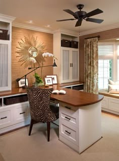 a home office with a zebra print chair and desk in front of a large window