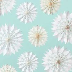 a blue and white wallpaper with paper snowflakes hanging from it's sides