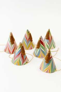 four multicolored lampshades with tassels on them, one is shaped like a cone