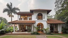 a large white house with lots of windows and palm trees in the front lawn area