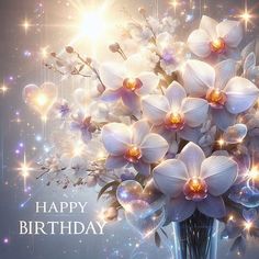 a vase filled with lots of white flowers on top of a blue table next to a happy birthday card