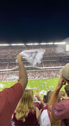 people at a football game are holding up white flags