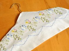 an ironing board with flowers on it and a hanger attached to the back