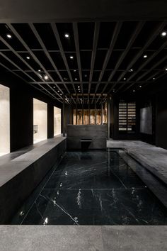 an indoor swimming pool surrounded by black walls