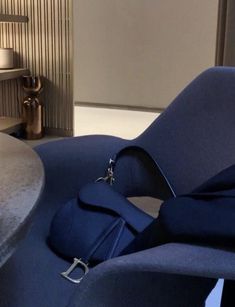 a blue chair sitting next to a table in a room with a lamp on top of it