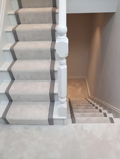 the stairs in this house are painted gray and white with grey carpeting on them