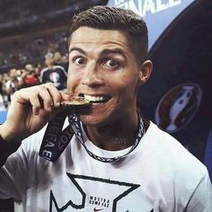 a man eating food while standing in front of a crowd at a sporting event with his mouth wide open