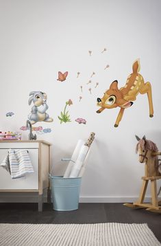 a child's room with some animals and butterflies on the wall, including a deer