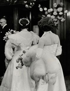 an old black and white photo of two women in wedding dresses walking down the aisle